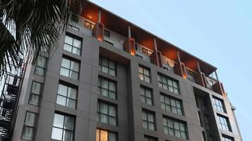 Un hôtel à plusieurs étages doté d’une architecture moderne, caractérisé par un toit plat et de grandes fenêtres.