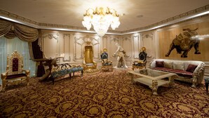 A luxurious room with ornate furniture, a grand chandelier, and a bull mural on the wall. - Myko Hotel Makassar (Makassar)
