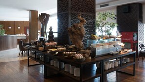 A buffet setup with various food items and a coffee station. - Myko Hotel Makassar (Makassar)