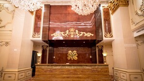 A grand lobby with a marble reception desk, ornate columns, and a patterned carpet. - Myko Hotel Makassar (Makassar)