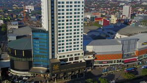 A hotel with a modern design, featuring a prominent MYKO logo on the building. - Myko Hotel Makassar (Makassar)