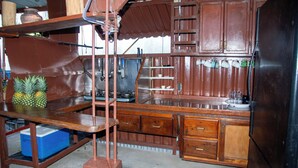 A rustic kitchen with wooden cabinets, a sink, and a refrigerator. - Hotel Restaurant Wuarao (Boca Chica)