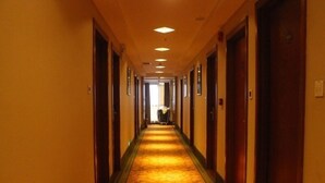 A hotel hallway with carpeted floors, wooden doors, and recessed lighting. - GreenTree Shell Shenzhen Henggang Wenti Square Xianle Road Hotel (Shenzhen)