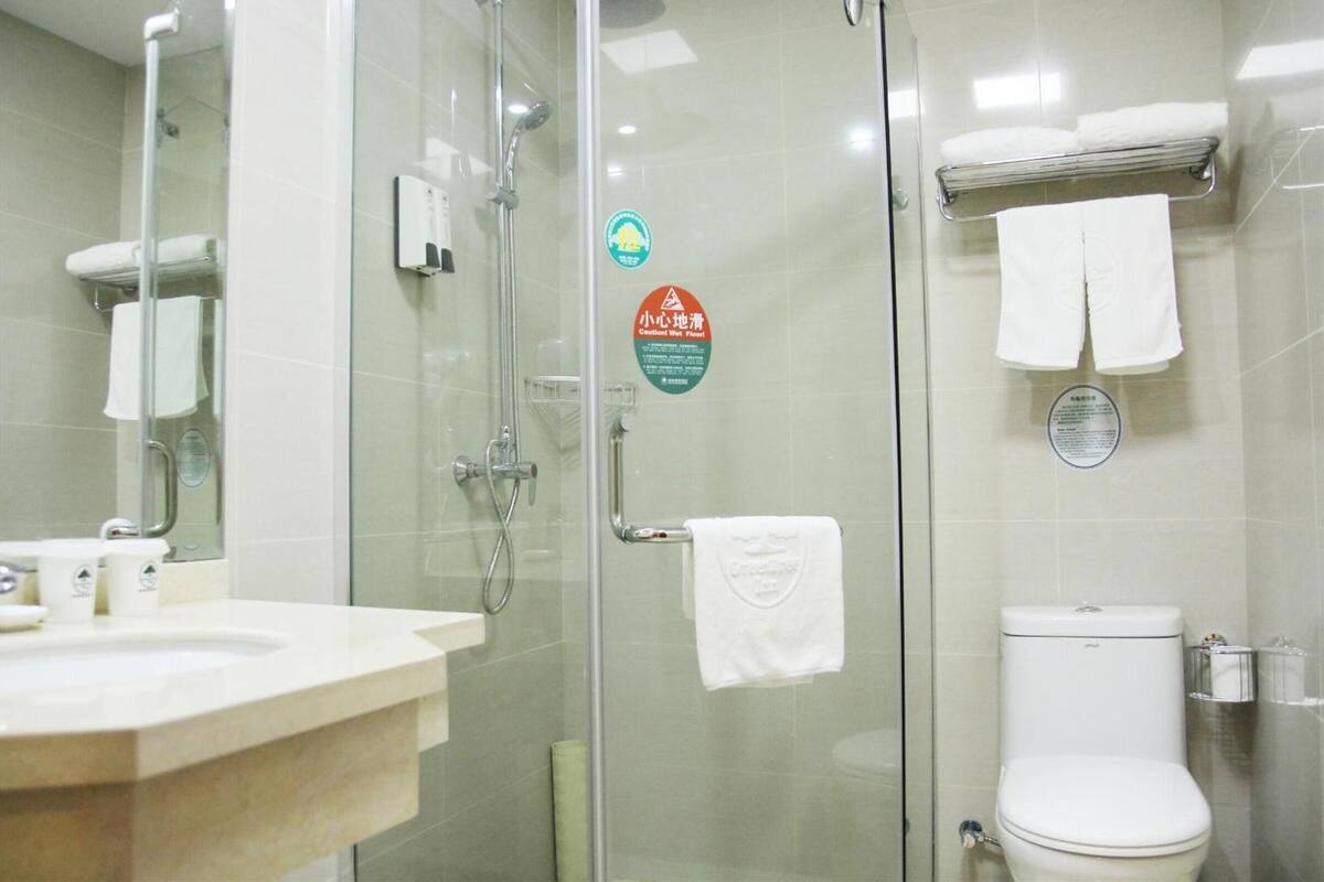 Une salle de bain moderne avec une douche à parois de verre, des toilettes et un lavabo avec un miroir.