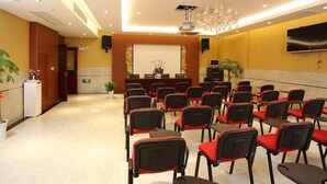 A conference room with rows of chairs, a podium, a projector screen, and a television on the wall. - GreenTree Inn KunShan Lujia Town Furong Road Express Hotel (Suzhou)