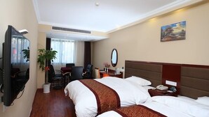 A hotel room with two beds, a TV, a desk with a chair, a plant, and a painting on the wall. - GreenTree Inn KunShan Lujia Town Furong Road Express Hotel (Suzhou)