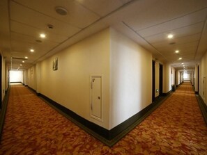 A long, narrow hotel corridor with carpeted floors and doors on both sides. - Greentree Inn Mong Kok Express Hote (Suzhou)