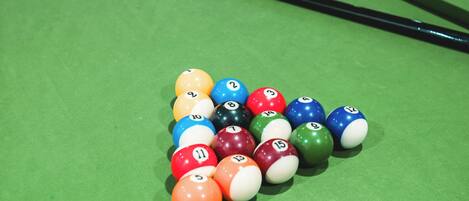 Une table de billard avec un jeu de billes disposées en forme de triangle.