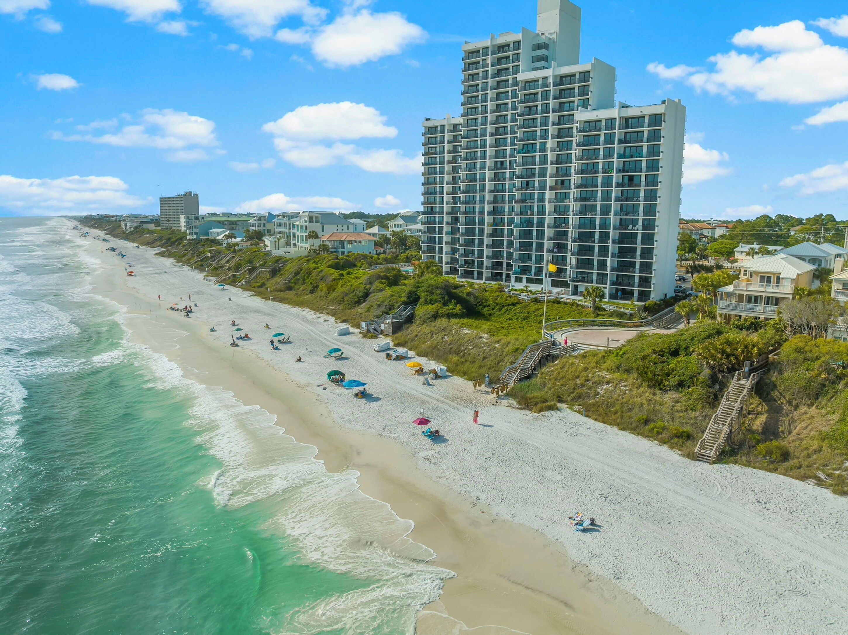 Een strand met een hoog hotel op de achtergrond.