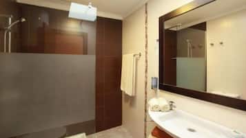 Une salle de bain moderne avec une douche, un lavabo et un grand miroir.