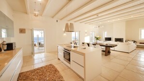 Uma cozinha espaçosa com uma ilha grande, eletrodomésticos modernos e vista para o exterior.