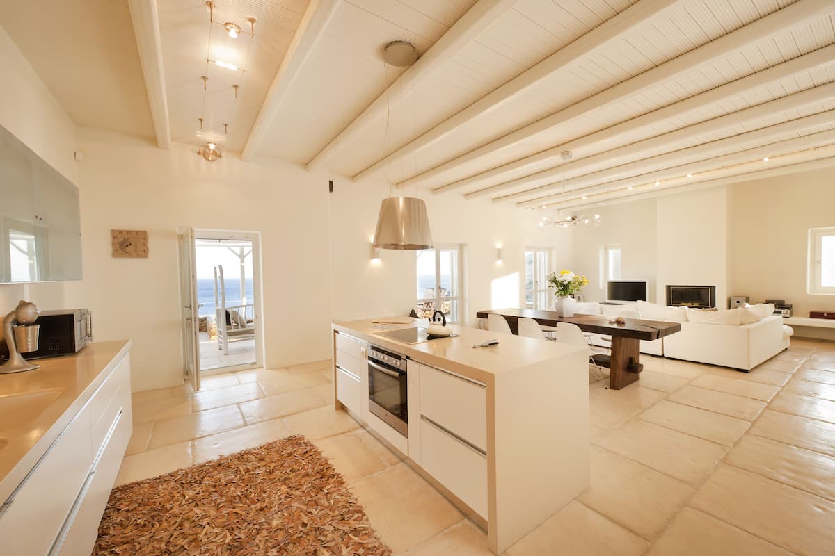 Una cocina amplia con una isla grande, electrodomésticos modernos y vistas al exterior.