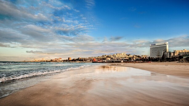 A beach with a cityscape in the background, including a hotel named "Hotel Mediterranean Court". - Garden Court Kings Beach (Gqeberha (Port Elizabeth))