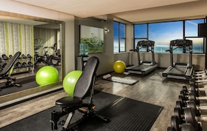 A gym with treadmills, exercise balls, and dumbbells.
