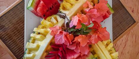 En tallerken med frugtskiver og blomster.