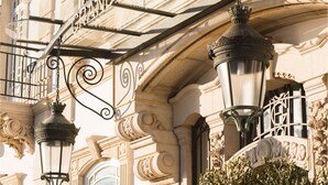 Des éléments architecturaux raffinés, notamment un balcon en fer forgé et des éléments décoratifs en métal.