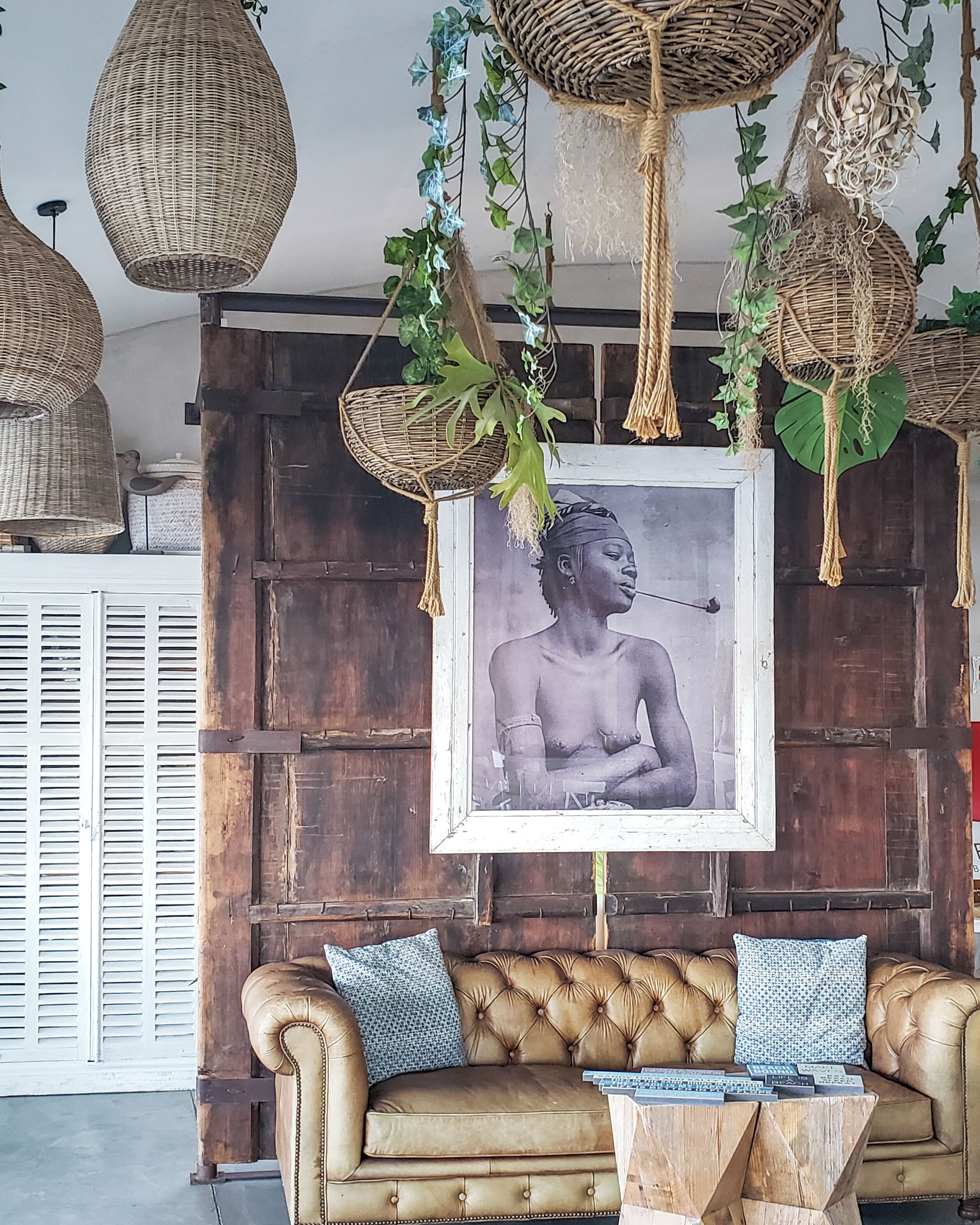 Ein Zimmer mit einer braunen Ledersofa, einem Holztisch und einem gerahmten Bild an der Wand.