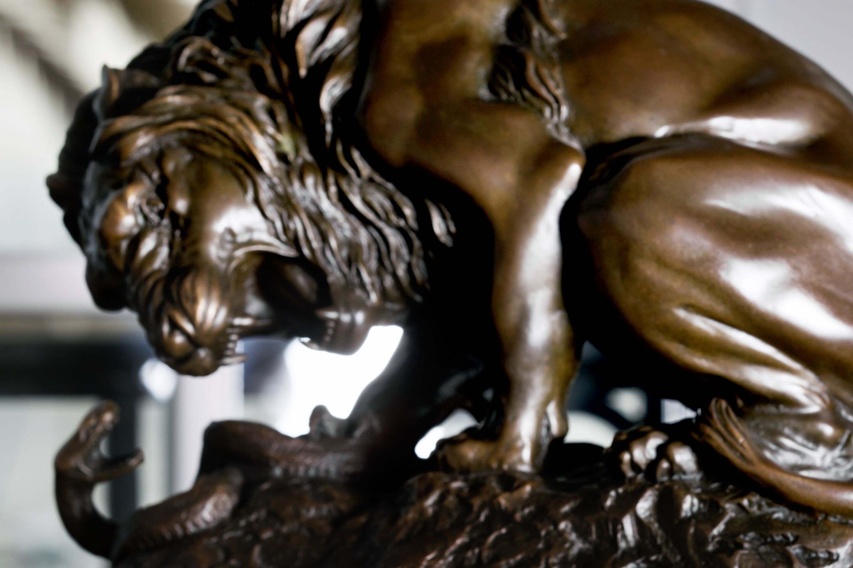 Primer plano de una escultura de bronce que representa a un león.