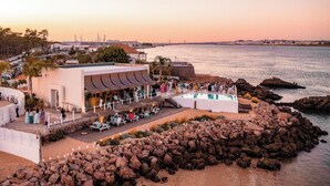 Un hôtel situé sur la côte, doté d’une piscine, d’un espace extérieur aménagé et offrant une vue sur la mer.