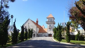 A large, historic building with a prominent tower and a symmetrical facade. - Recanto Brumas (Campos do Jordão)