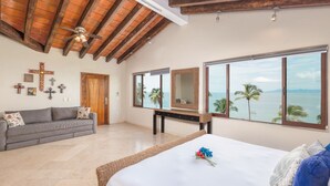 A bedroom with a large window, a bed, a sofa, and a ceiling fan. - Casa Bahia Linda by Kivoya (Puerto Vallarta)