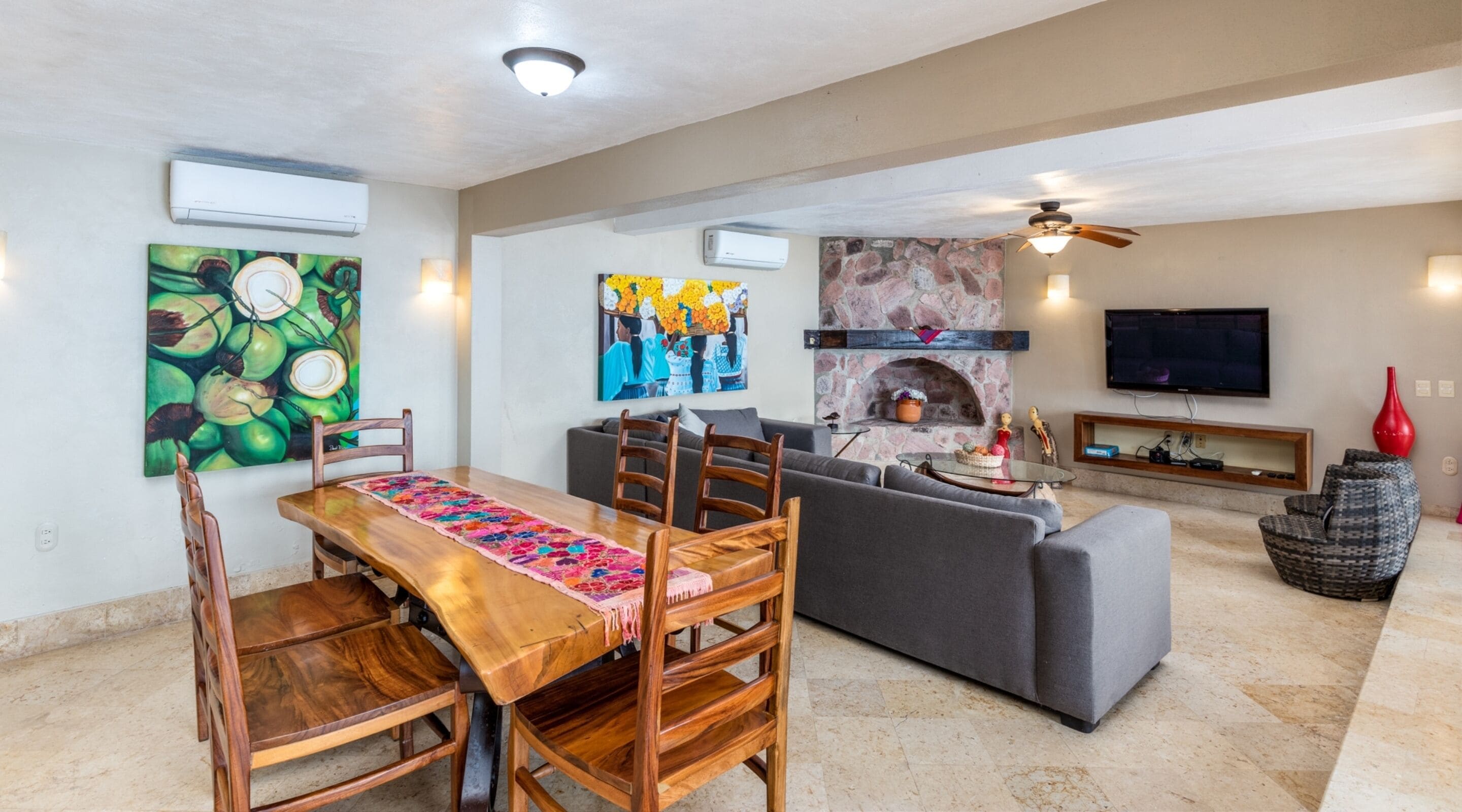 A spacious living area with a dining table, sofa, and fireplace.