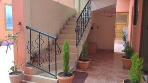 A staircase with a metal railing, potted plants, and a sign indicating a dining room. - Hotel Wendy Mar (Copacabana)