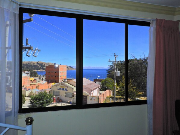 Una ventana con vistas despejadas a un pueblo costero, edificios y una masa de agua.