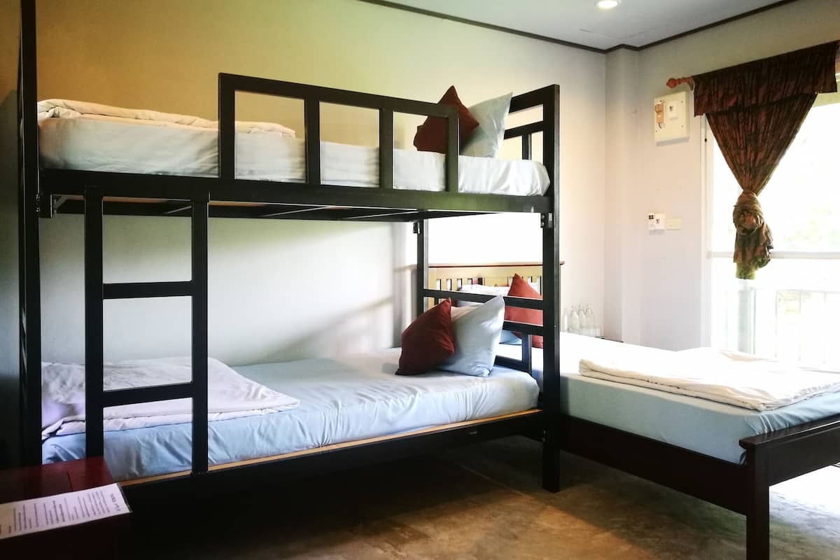 Une chambre avec un lit superposé, une fenêtre et une table avec un menu.