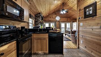 L’intérieur d’une cabane en bois comprend une cuisine équipée d’une cuisinière, d’un four à micro-ondes et d’un lave-vaisselle.