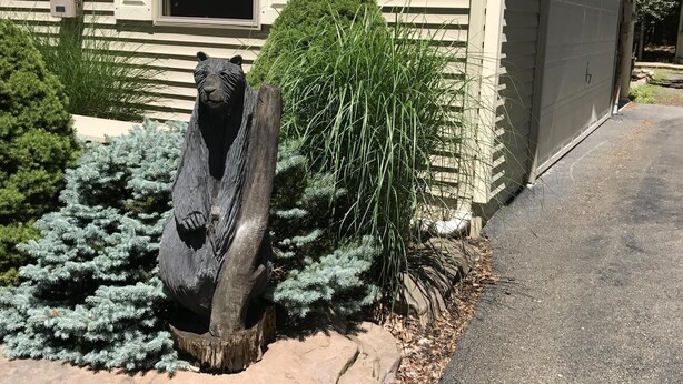 A house with a garage door, a window with blinds, and a bear statue in the front yard. - 6 BDRM BEAUTIFUL HOME ON ONE FLOOR "LIONS DEN" -Big Boulder,Camelback,Jack Frost (Lake Harmony)
