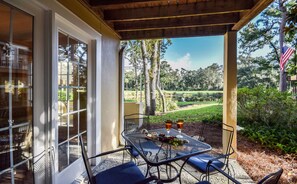 An outdoor patio with a table set for two, featuring a bottle of wine, cheese, and grapes. - BEACH and GOLF RESORT Luxury Lagoon & Golf View Villa 2 Patios+KING BED (Hilton Head Island)