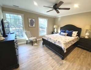 A bedroom with a bed, a chair, a dresser, and a ceiling fan. - BEACH and GOLF RESORT Luxury Lagoon & Golf View Villa 2 Patios+KING BED (Hilton Head Island)