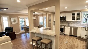 A spacious kitchen with a central island, wooden flooring, and modern appliances.