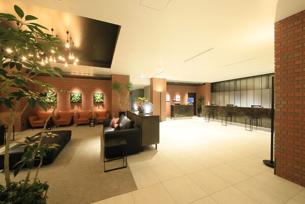 A modern lobby with seating areas, a reception desk, and a bar. - Richmond Hotel Yokohama Ekimae (Yokohama)