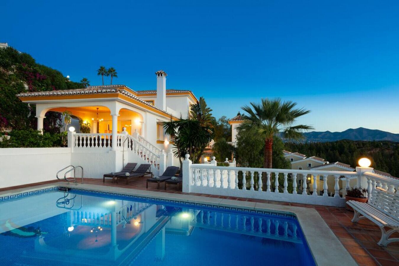 A poolside area with a clear view of a mountain range in the background.