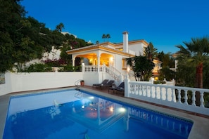 A pool area with a white fence, lounge chairs, and a staircase leading to a house with a balcony. - Luxury Villa with Heated Pool, Stunning Sea Views & Near Beach (Las Lagunas de Mijas)