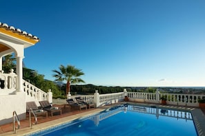 Ein Poolbereich mit Liegestühlen und Blick auf die Landschaft.