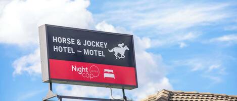 A sign for the Horse & Jockey Hotel & Motel with a Nightcap logo.