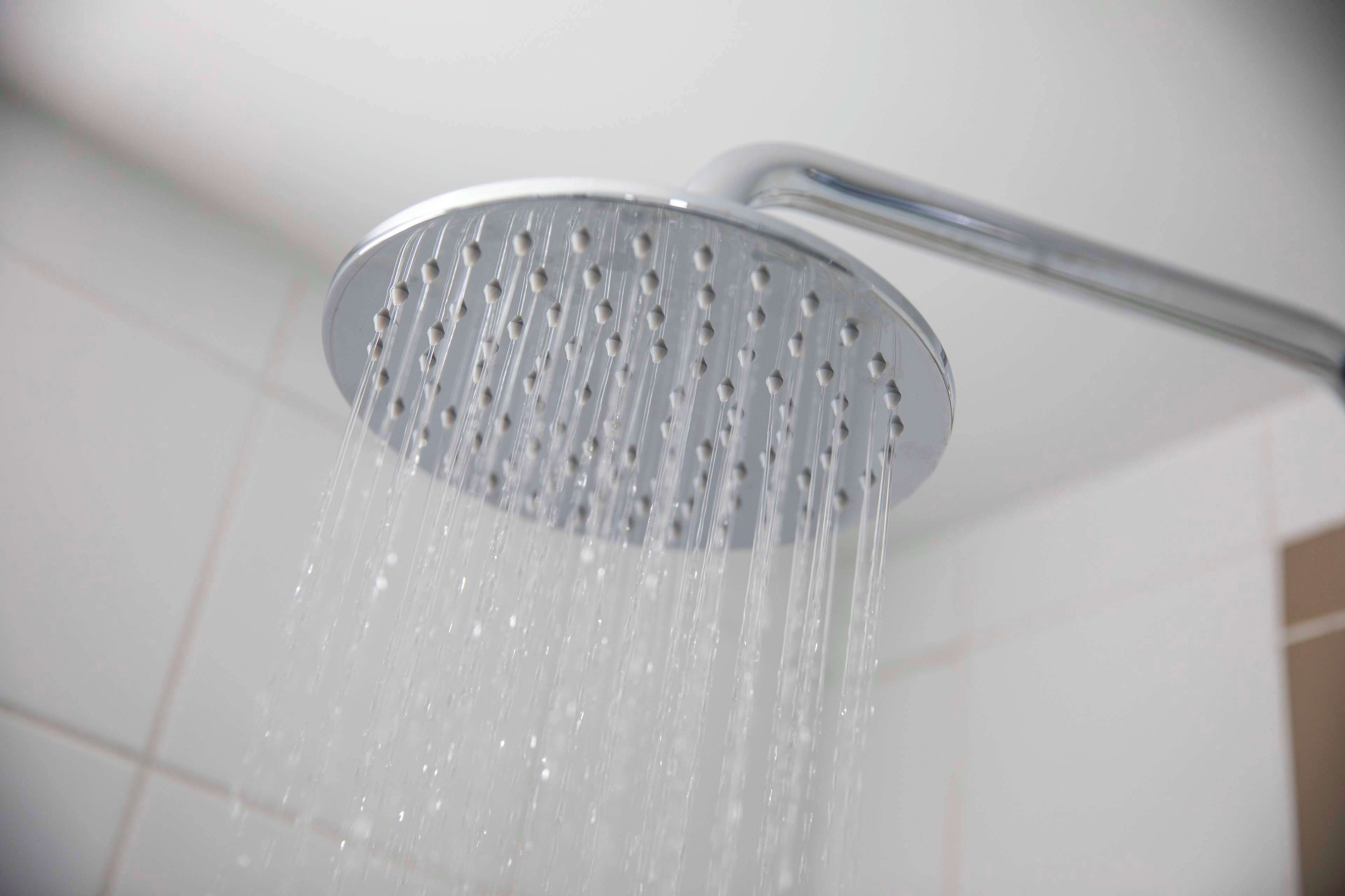Eine Duschbrause, aus der Wasser fließt.
