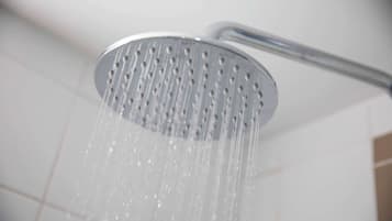 Eine Duschbrause, aus der Wasser fließt.