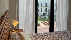 A hotel room with a bed, a lamp, and a view of the outside. - L Estartit: Apartment/ flat - L''ESTARTIT (L'ESTARTIT)
