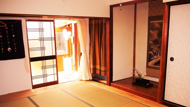 Ein traditioneller japanischer Raum mit Tatami-Böden, Schiebetüren und einem Shoji-Bildschirm.