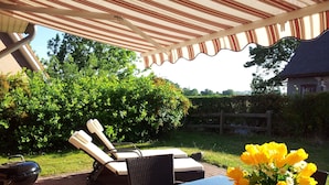 An outdoor patio area with a table, chairs, and a grill. - The best time on the largest island of Germany enjoy. (Ummanz/Waase)