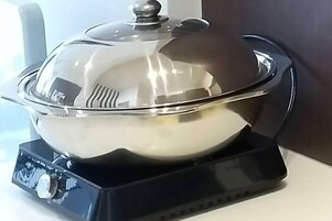 En slow cooker i rostfritt stål med en svart bas och en kontrollpanel.