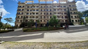 Un hotel de varios pisos con balcones, un patio central y cielo despejado.
