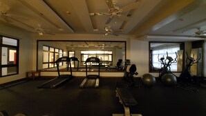 Un gimnasio con cintas de correr, elípticas y pesas sueltas.