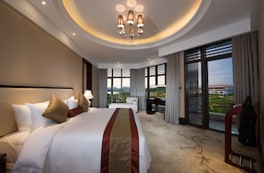 Habitación de hotel con una cama grande, un escritorio, una silla y vistas al exterior.