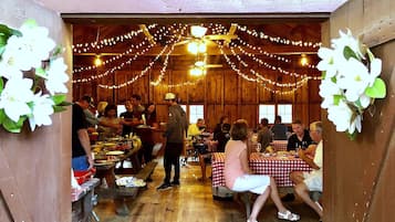 An indoor dining area with wooden walls and tables covered with checkered tablecloths.