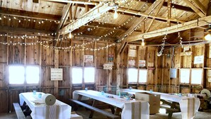 Ein rustikales Holzinterieur mit Picknicktischen und Lichterketten.